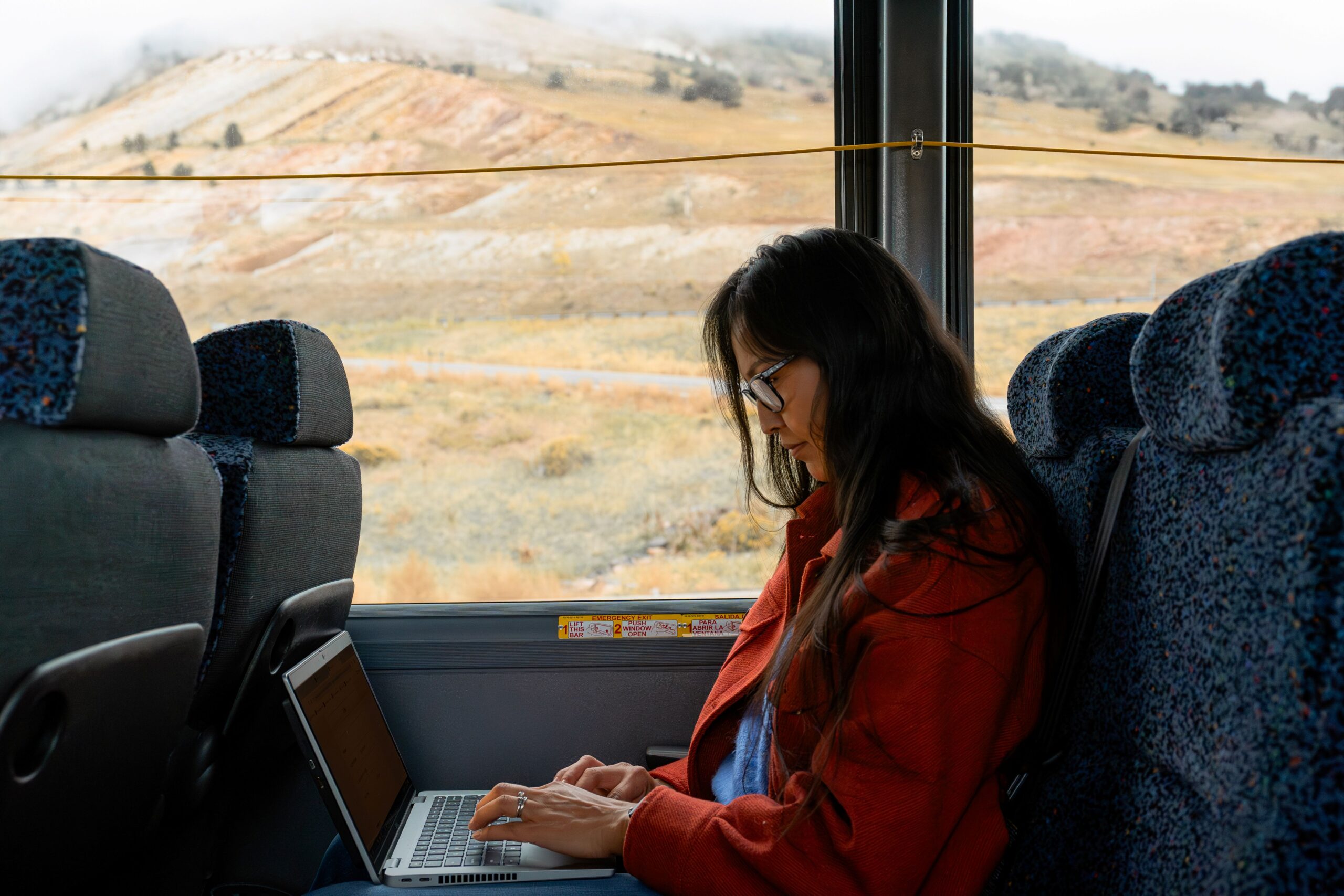 Woman working on laptop while riding in bus